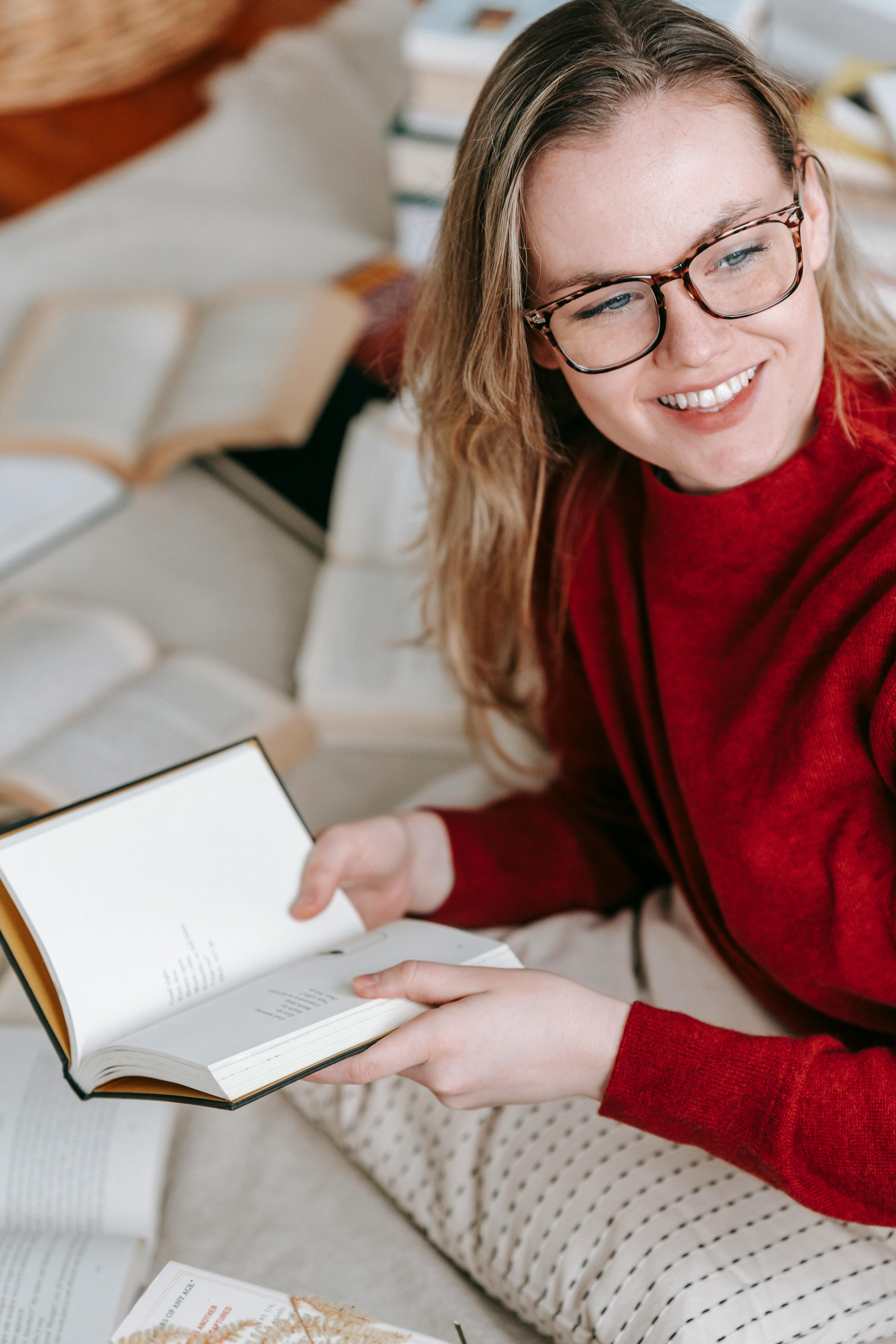 cheerful woman reading book on floor