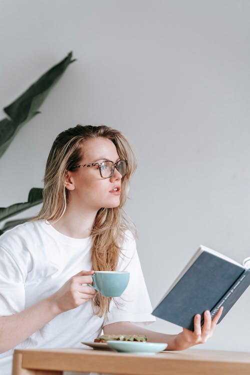 Free Woman with cup of coffee and planner pondering Stock Photo