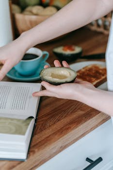 A serene morning scene with a woman preparing a healthy avocado breakfast alongside coffee and toast.