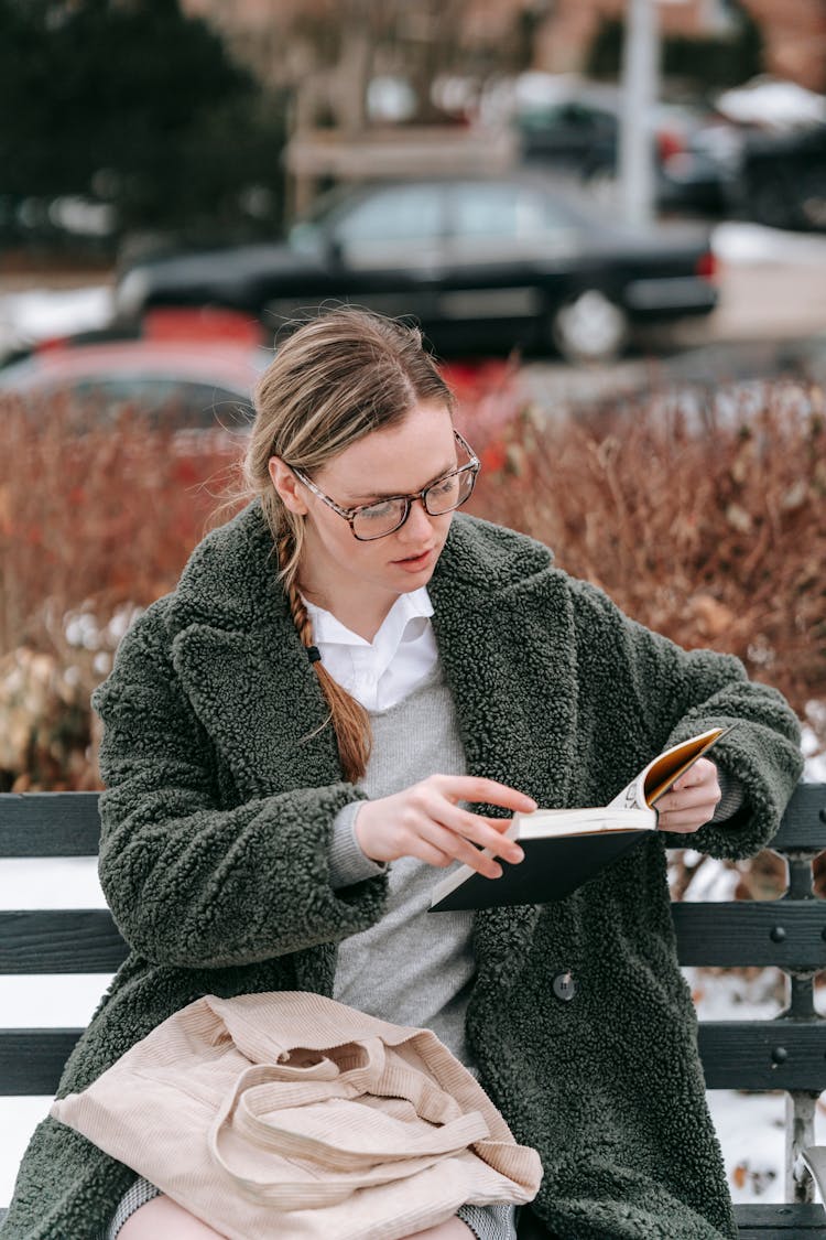 Young Woman Reading Book In Winter Park