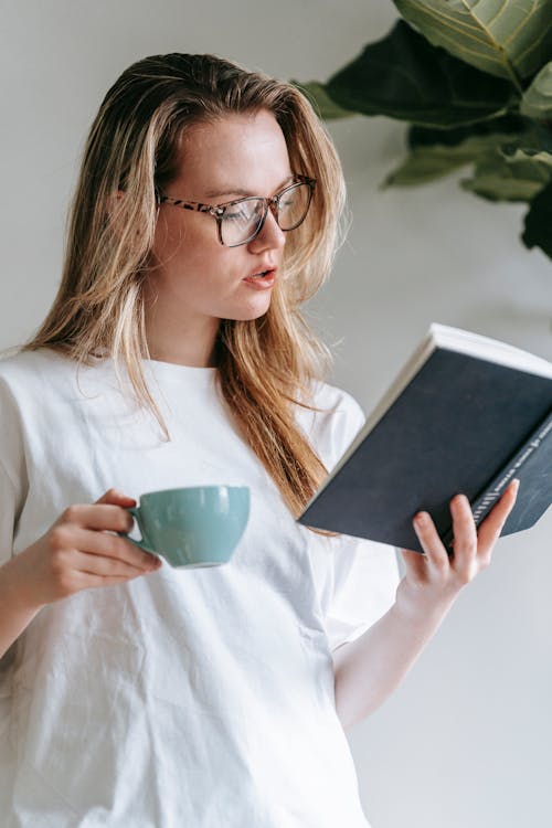 Free Calm woman reading book in light room Stock Photo