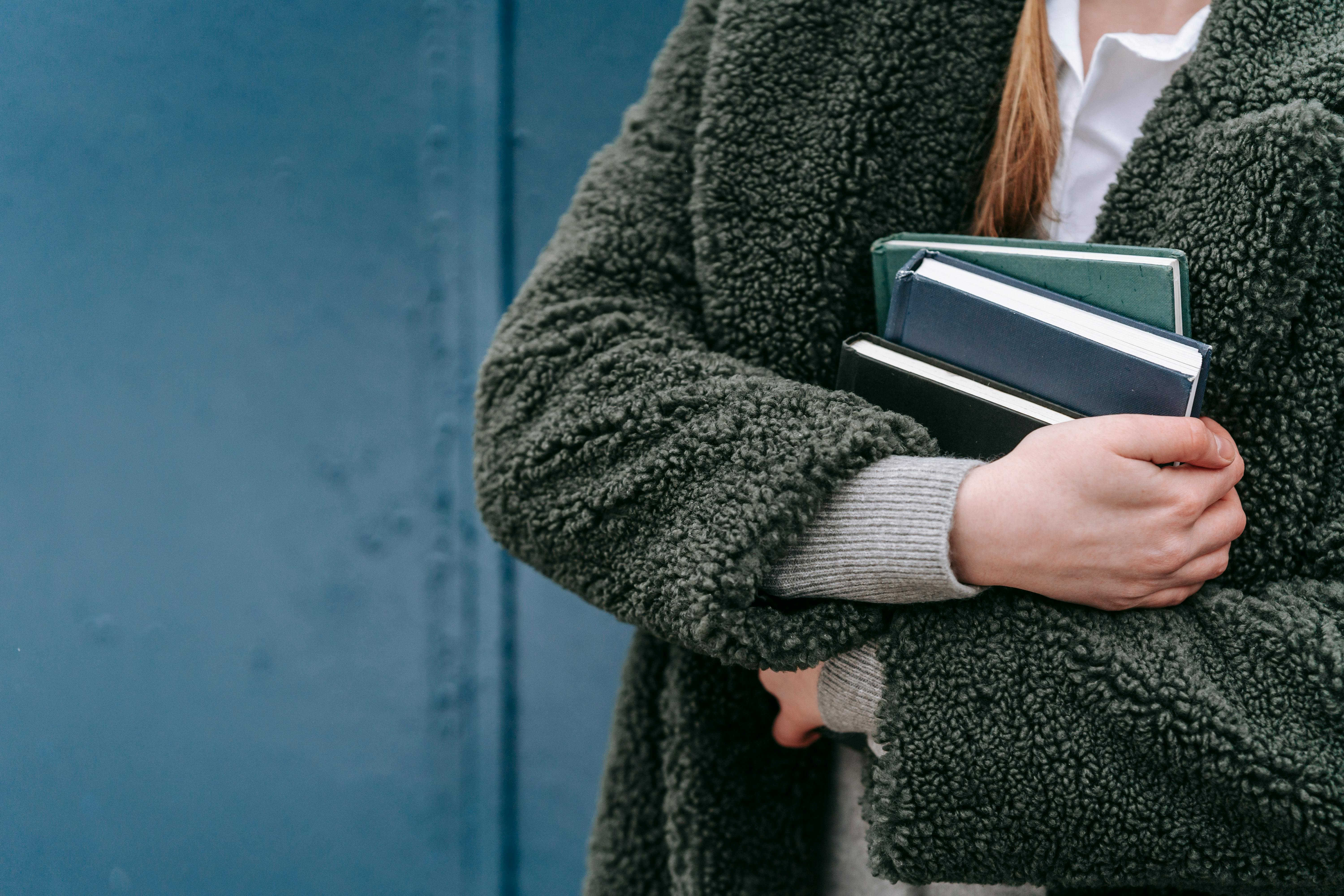 crop woman with books on street