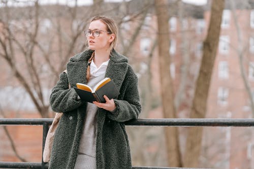 Thoughtful woman with book in park