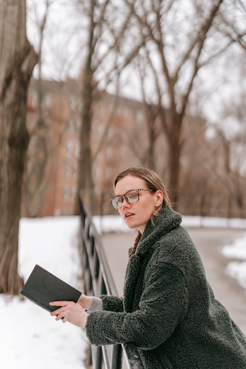 Young woman with open book in winter park