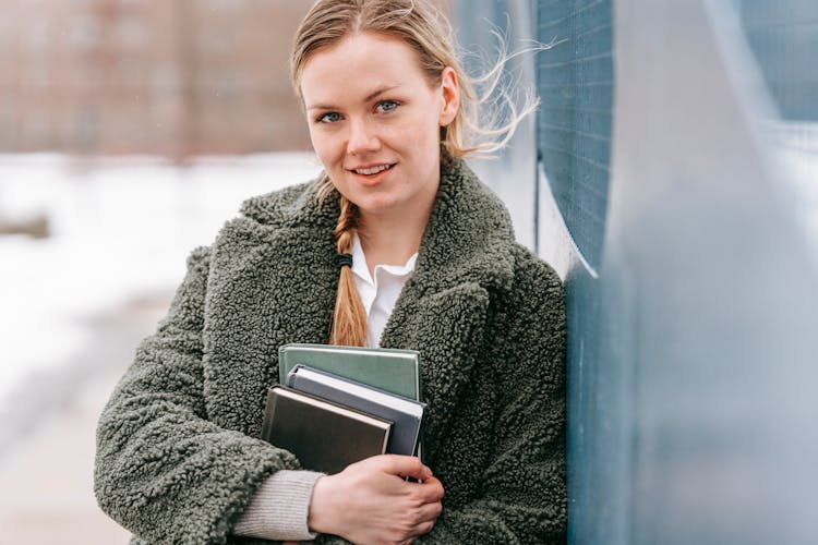 Crop Student With Books And Flying Hair In Winter Town