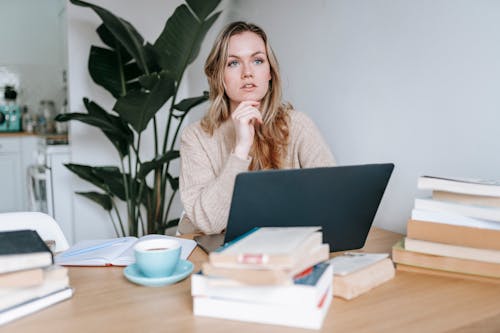 Focused businesswoman thinking on project at laptop at home