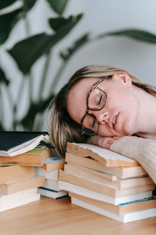 Free Young woman lying on books Stock Photo