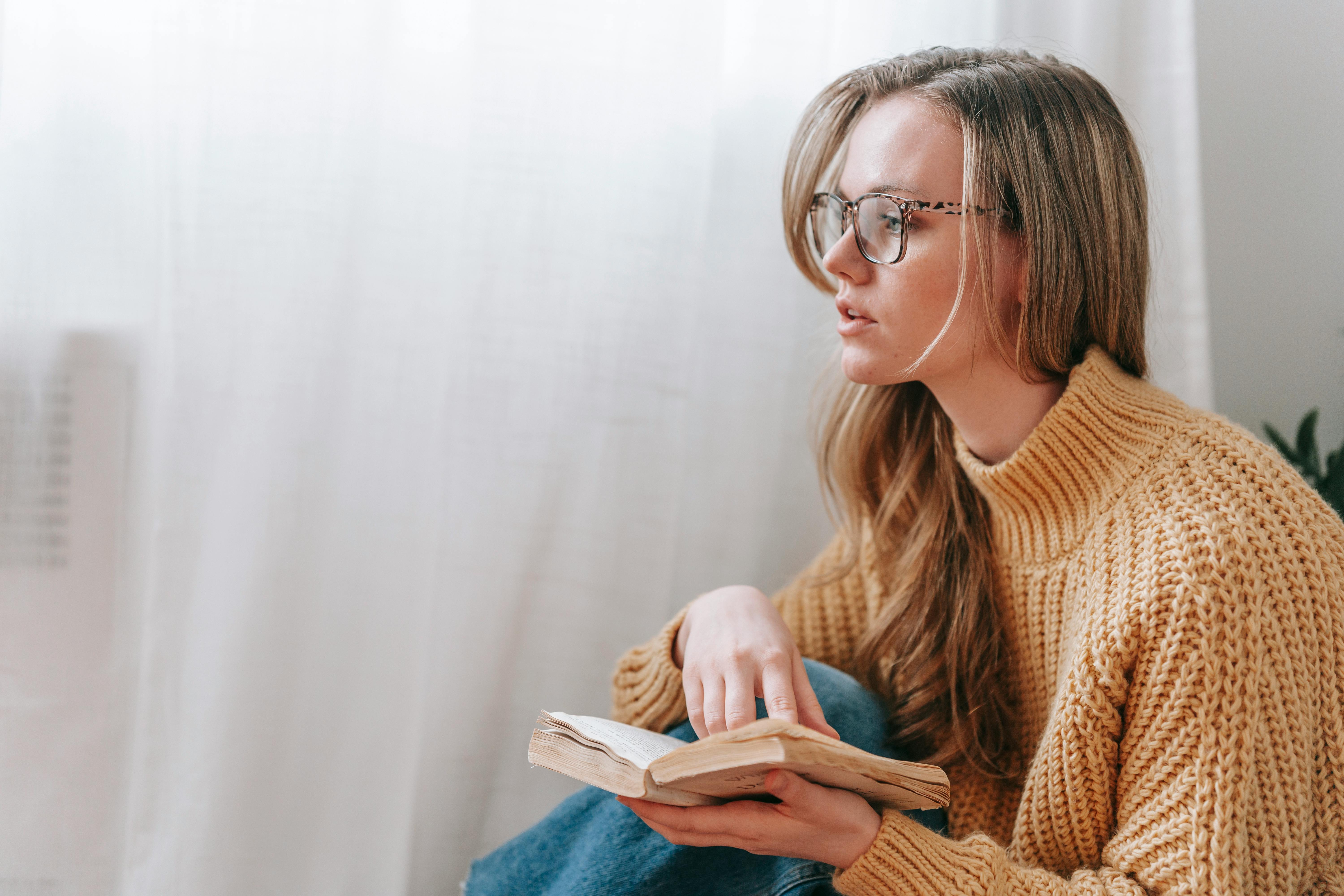 thoughtful young woman with book