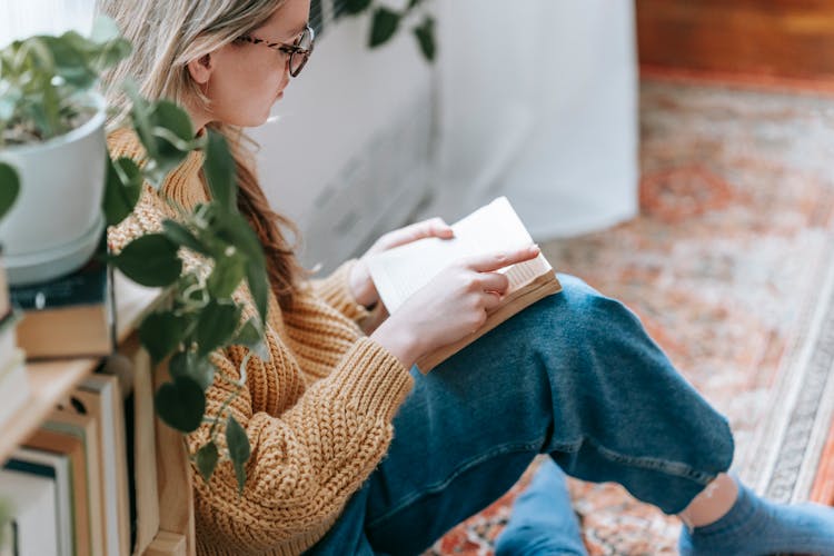 Woman Sitting On Carpet And Reading Book