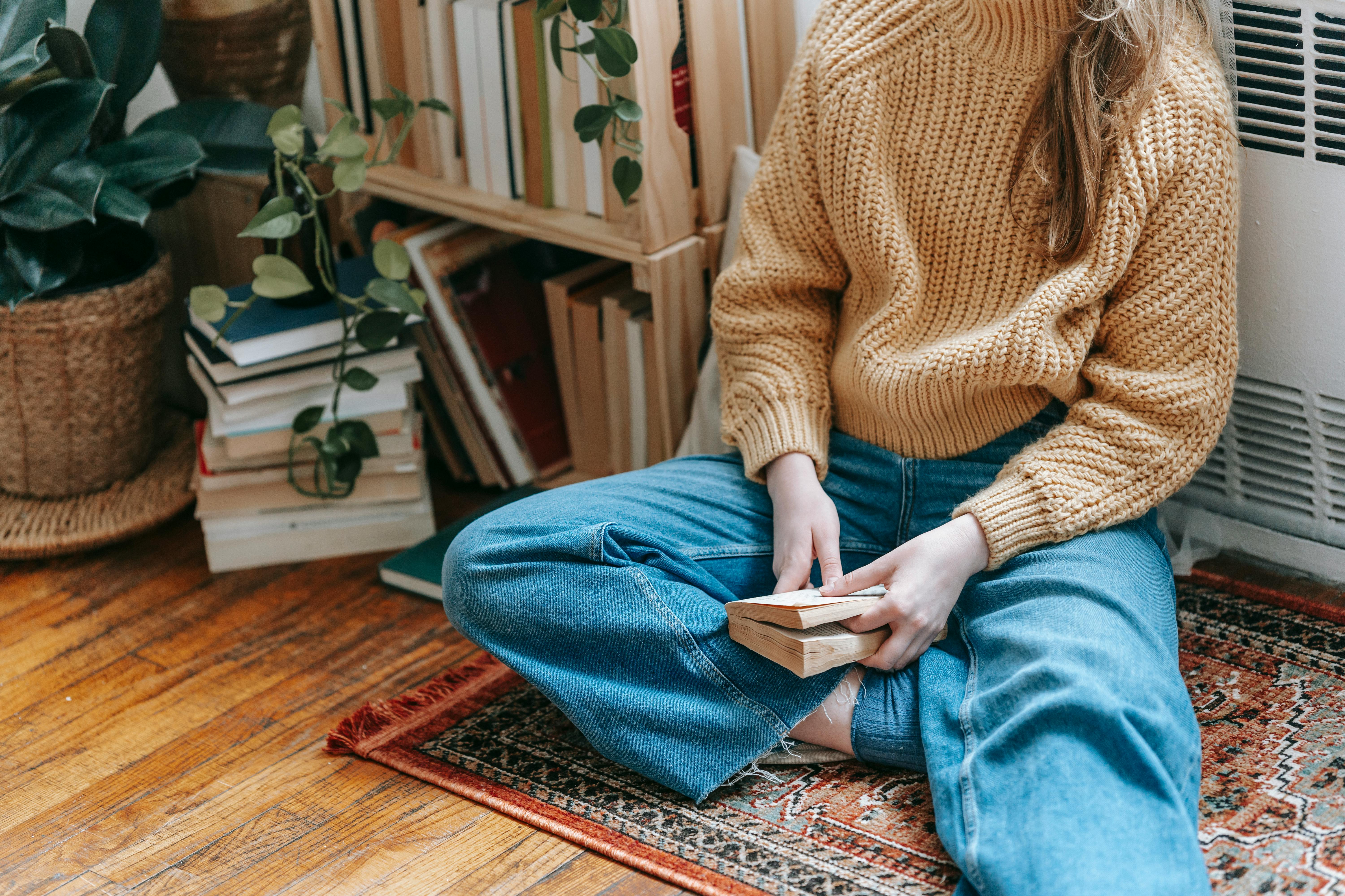 crop woman resting on floor with book