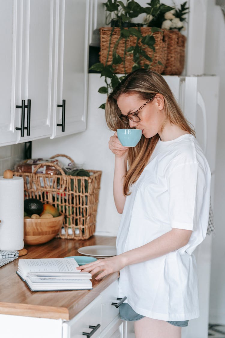 A Woman Drinking Coffee While Reading A Book