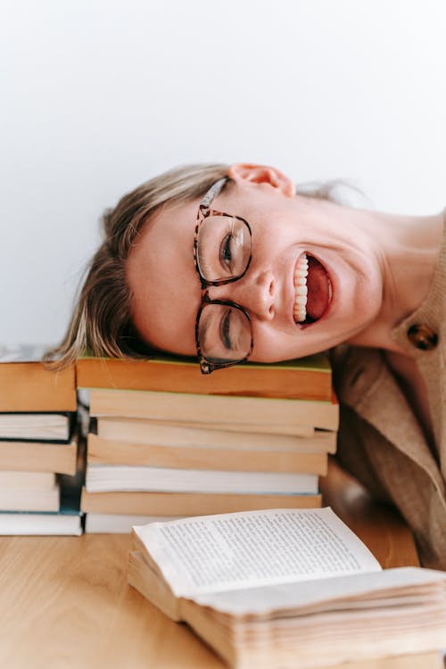 Gratis stockfoto met boeken, bril, glimlachen