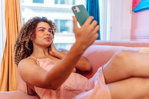 Free Woman in White Tank Top Holding Black Smartphone Stock Photo