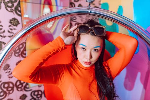 Close portrait in orange against a painted backdrop — photo by RDNE Stock project on Pexels