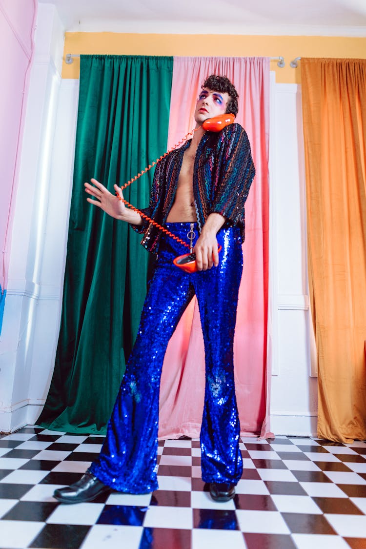 A Man Standing In Retro Clothes Holding A Vintage Telephone