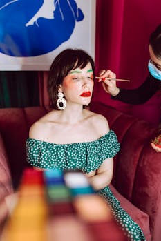 A woman getting vibrant makeup applied, showcasing fashion and style.