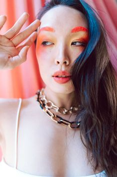 Vibrant fashion portrait of a woman in bold makeup, exuding style and elegance.