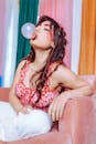 一位时尚的年轻女子吹泡泡糖的肖像，展示了充满活力的街头风格和室内妆容