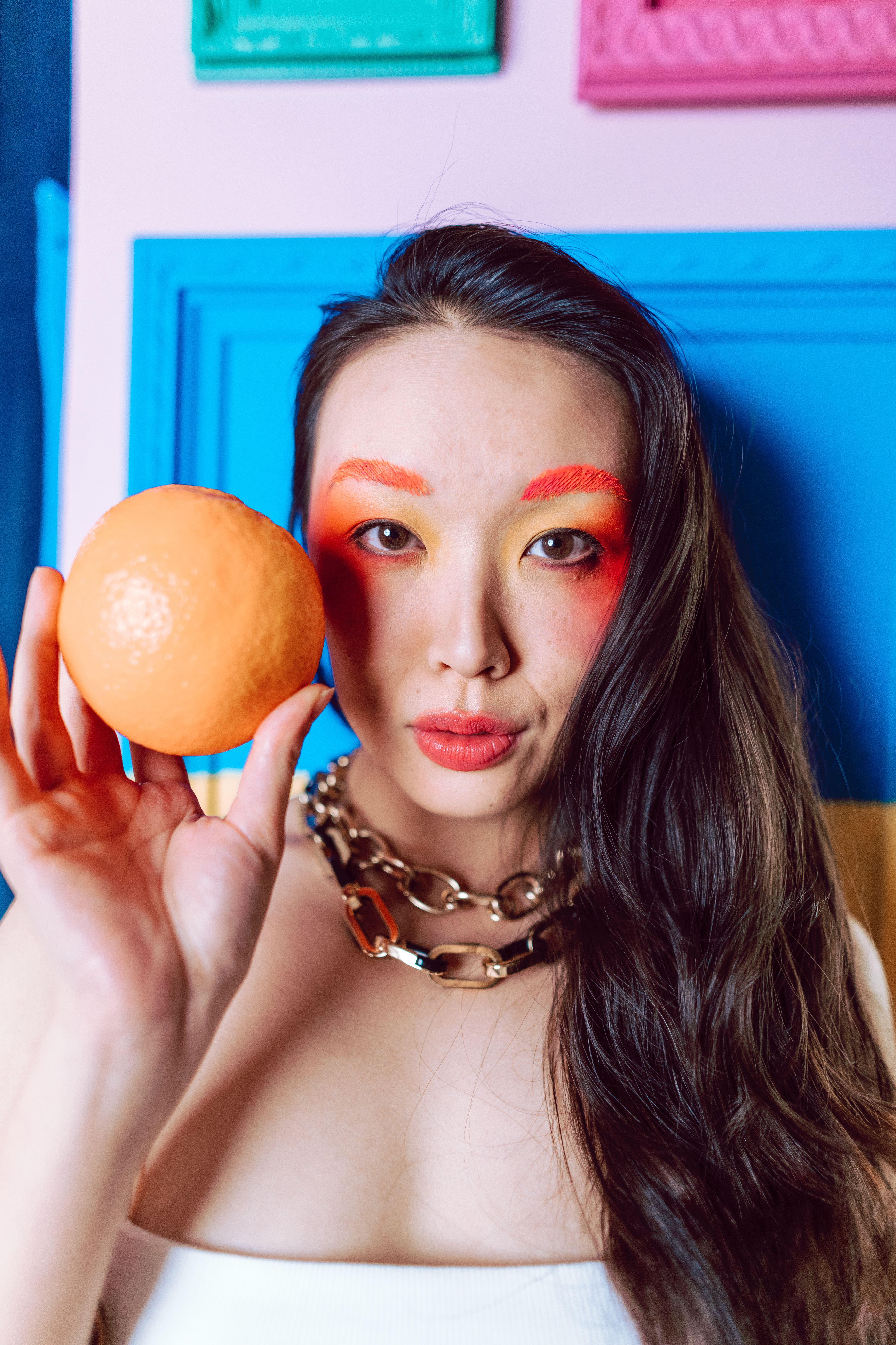 A Portrait of a Woman Holding an Orange · Free Stock Photo