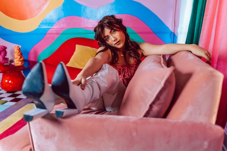 A Woman In High Heels Sitting On A Chair