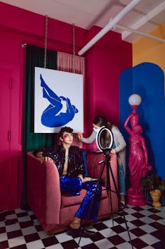 Colorful portrait of an adult being styled by a makeup artist in a creative studio setting.