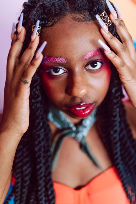 Stylish portrait featuring bold makeup and colorful fashion with a focus on vibrant expression.