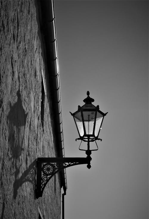 A Grayscale of a Lamp on the Wall
