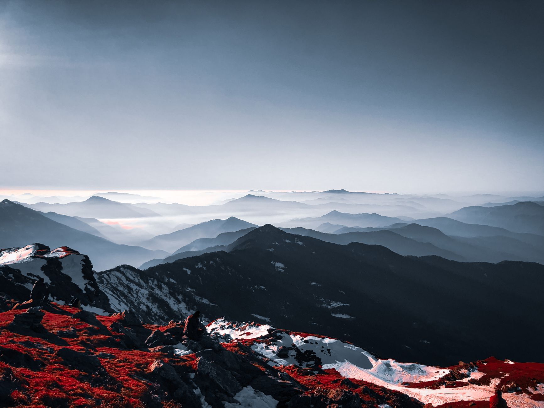 A breathtaking view of a snow-capped mountain range under a clear sky at sunrise in India.