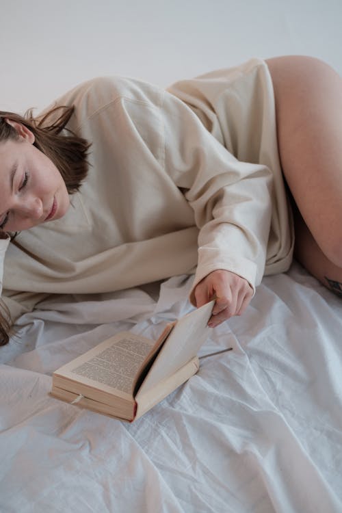 Free Sensual female reading book on bed Stock Photo