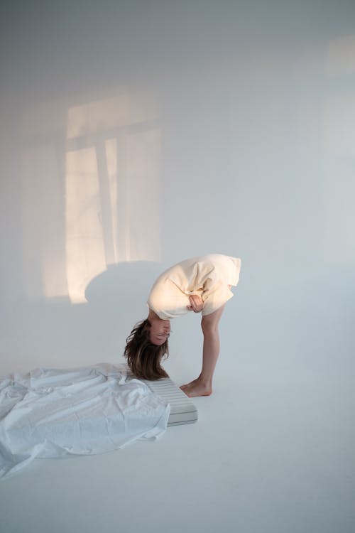 Free Young woman bending forward near mattress Stock Photo