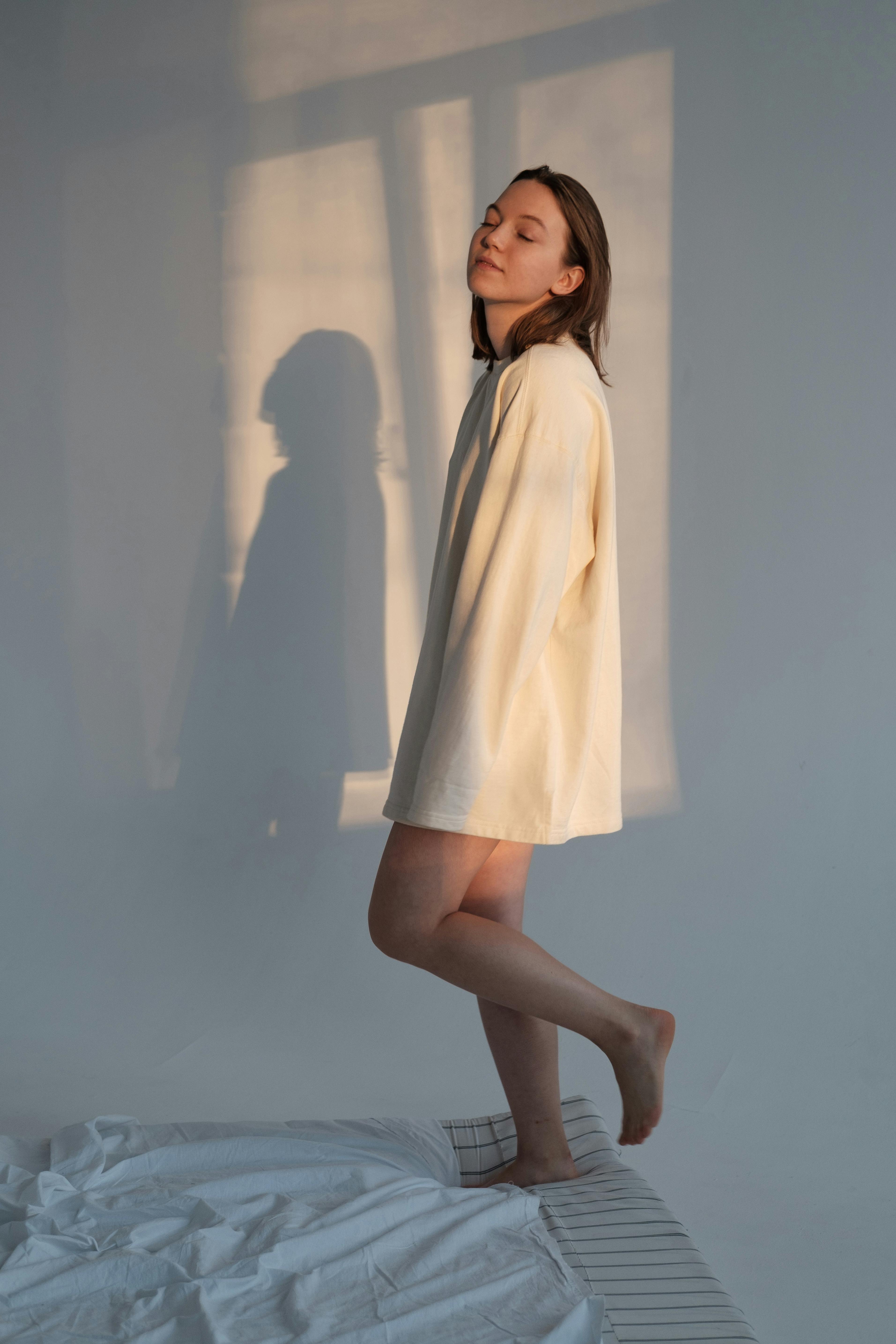 young woman walking on mattress in morning