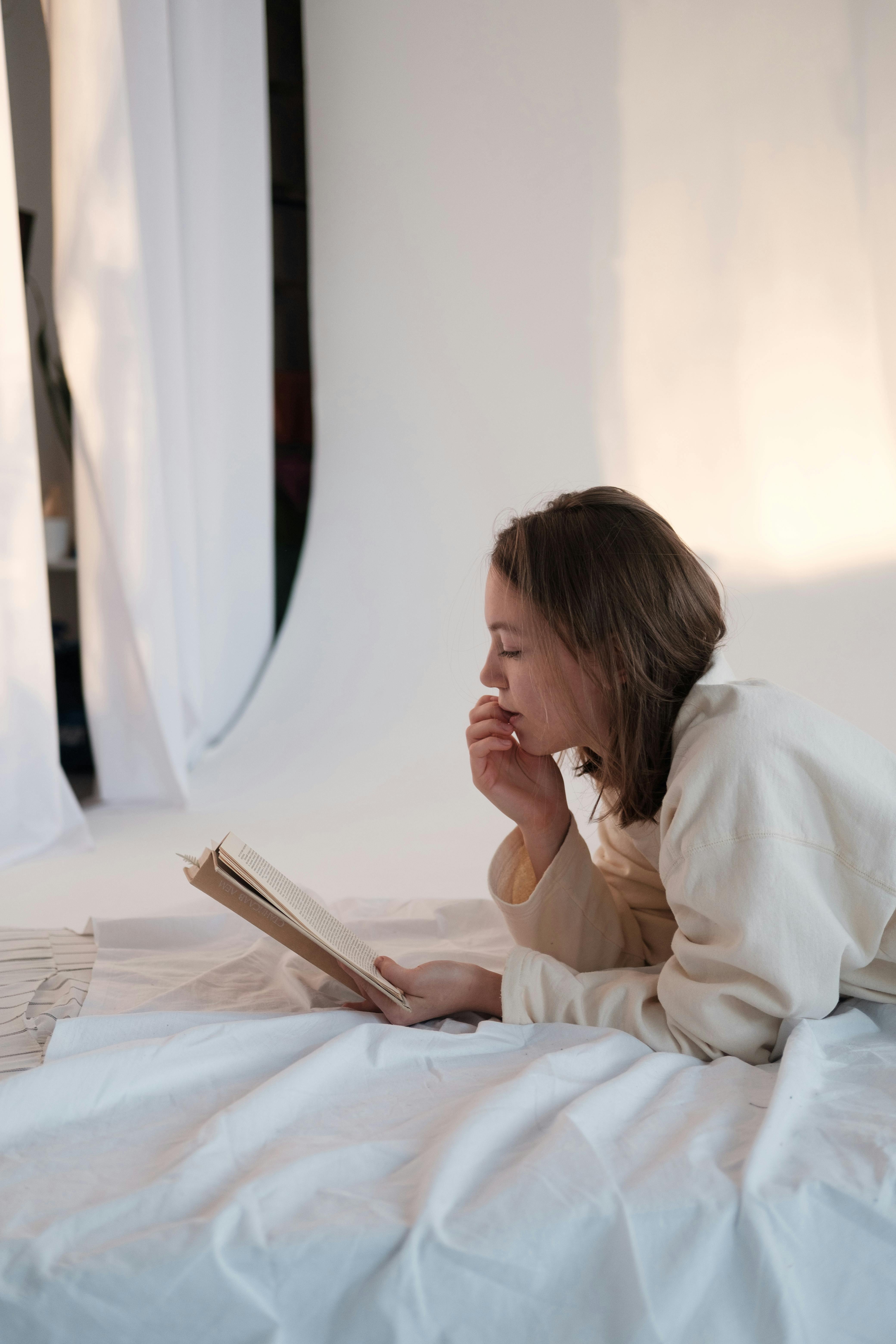 young female reading interesting book in morning