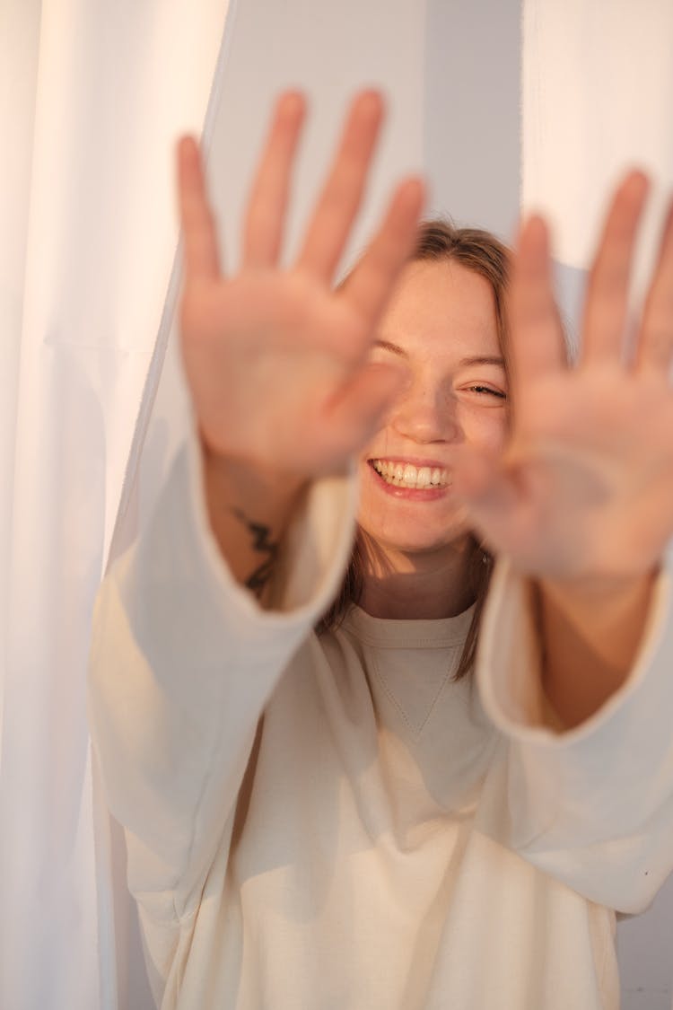 Optimistic Female Hiding Face From Camera