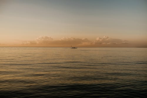 Silhouette of Boat on Sea during Sunset