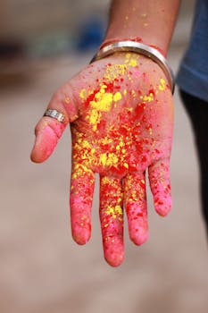 Close-up of a woman’s hand covered in bright Holi festival colors showcasing cultural celebration.