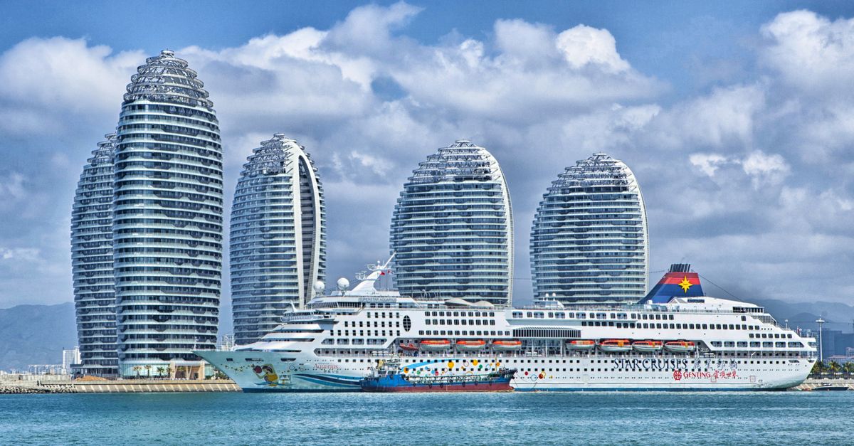 A modern city skyline with a cruise ship docked at the harbor.