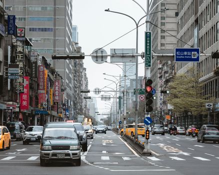 Street view in Taipei with busy traffic and Songshan Station signage in view.