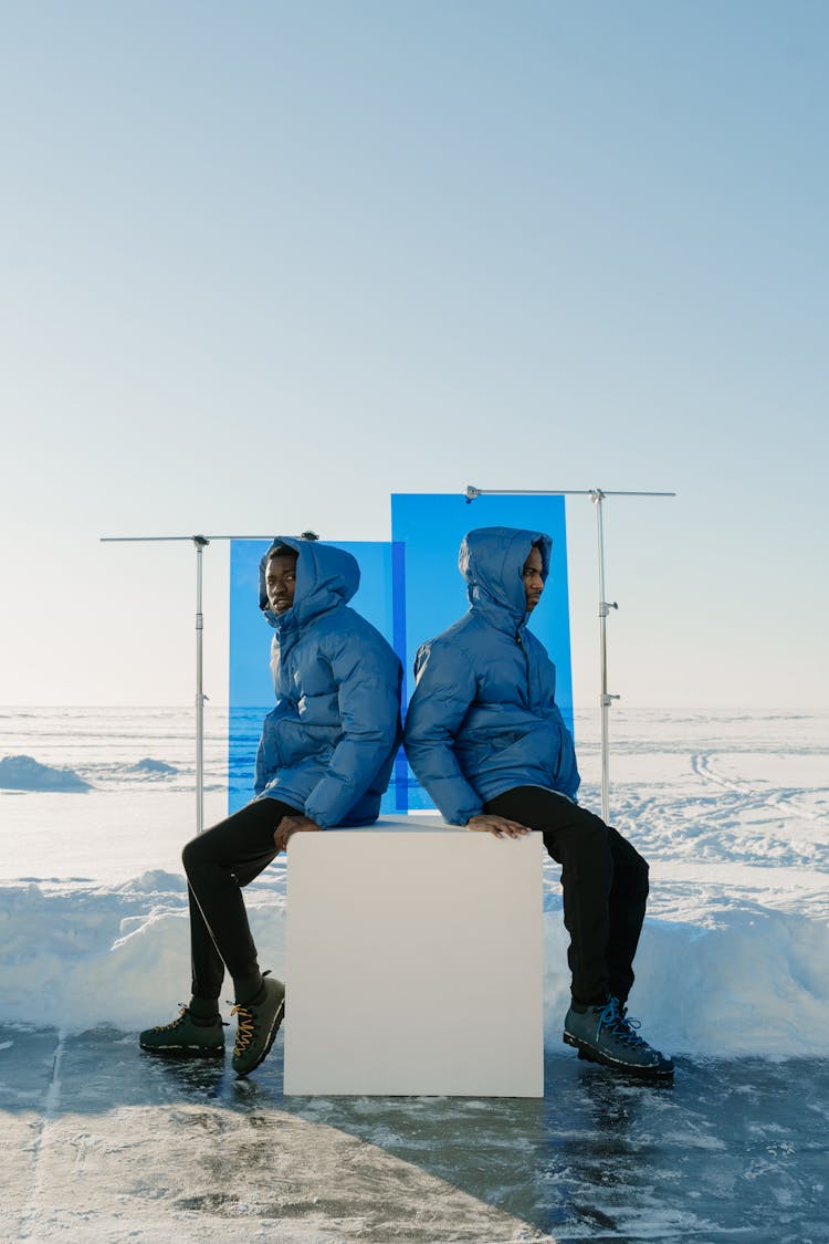 Men Wearing Blue Jackets In A Valley In Winter 