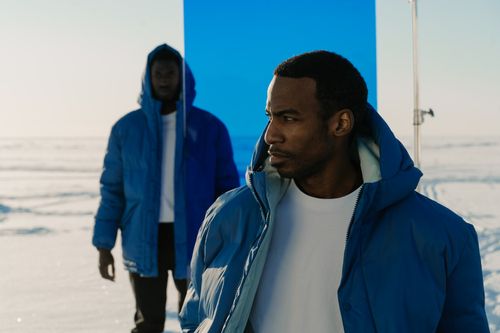 Free Stylish men in blue jackets stand against a snowy backdrop, showcasing winter fashion. Stock Photo