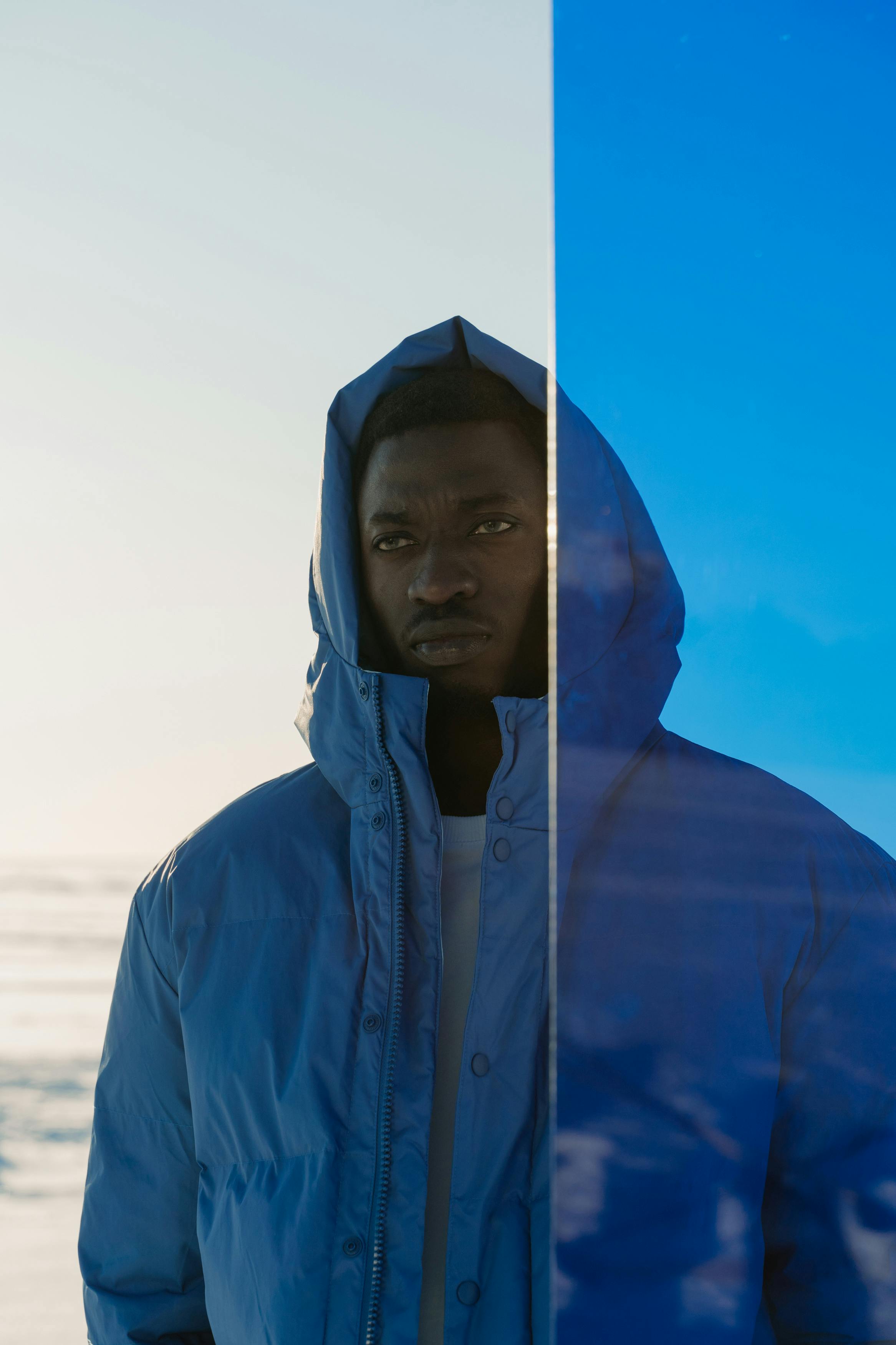 Portrait of a man in a blue jacket gazing afar, outdoors.