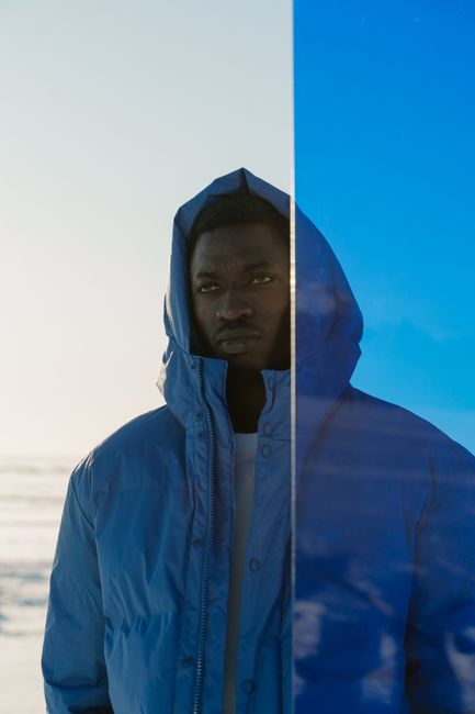 Portrait of a man in a blue jacket gazing afar, outdoors.