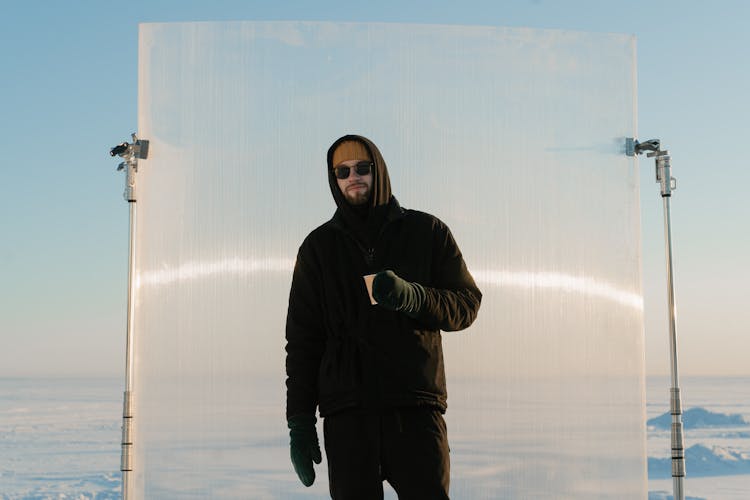 Man In Black Hoodie Standing In Front Of A Backdrop On A C Stand