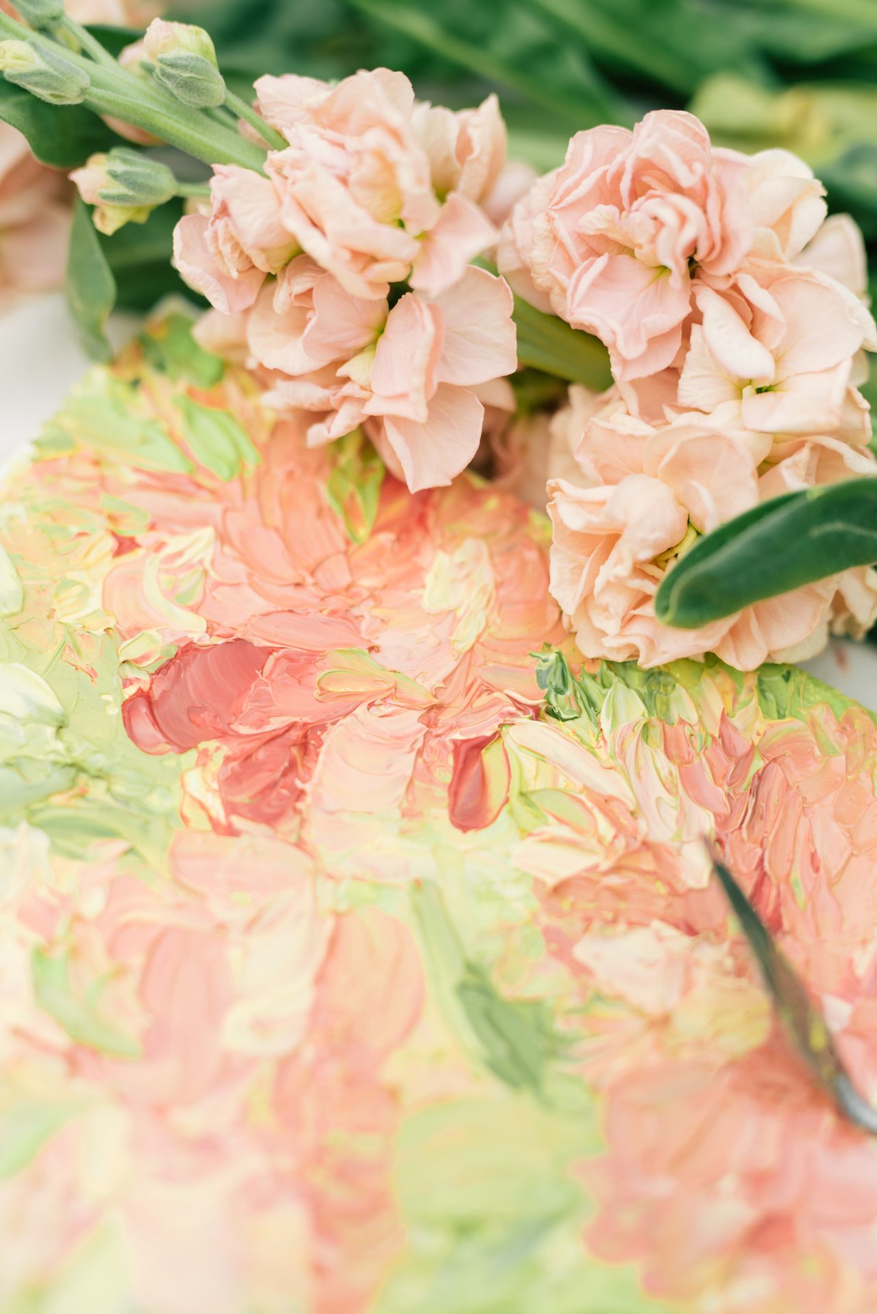 Elegant close-up of pink flowers and a vibrant oil painting, showcasing artistic texture