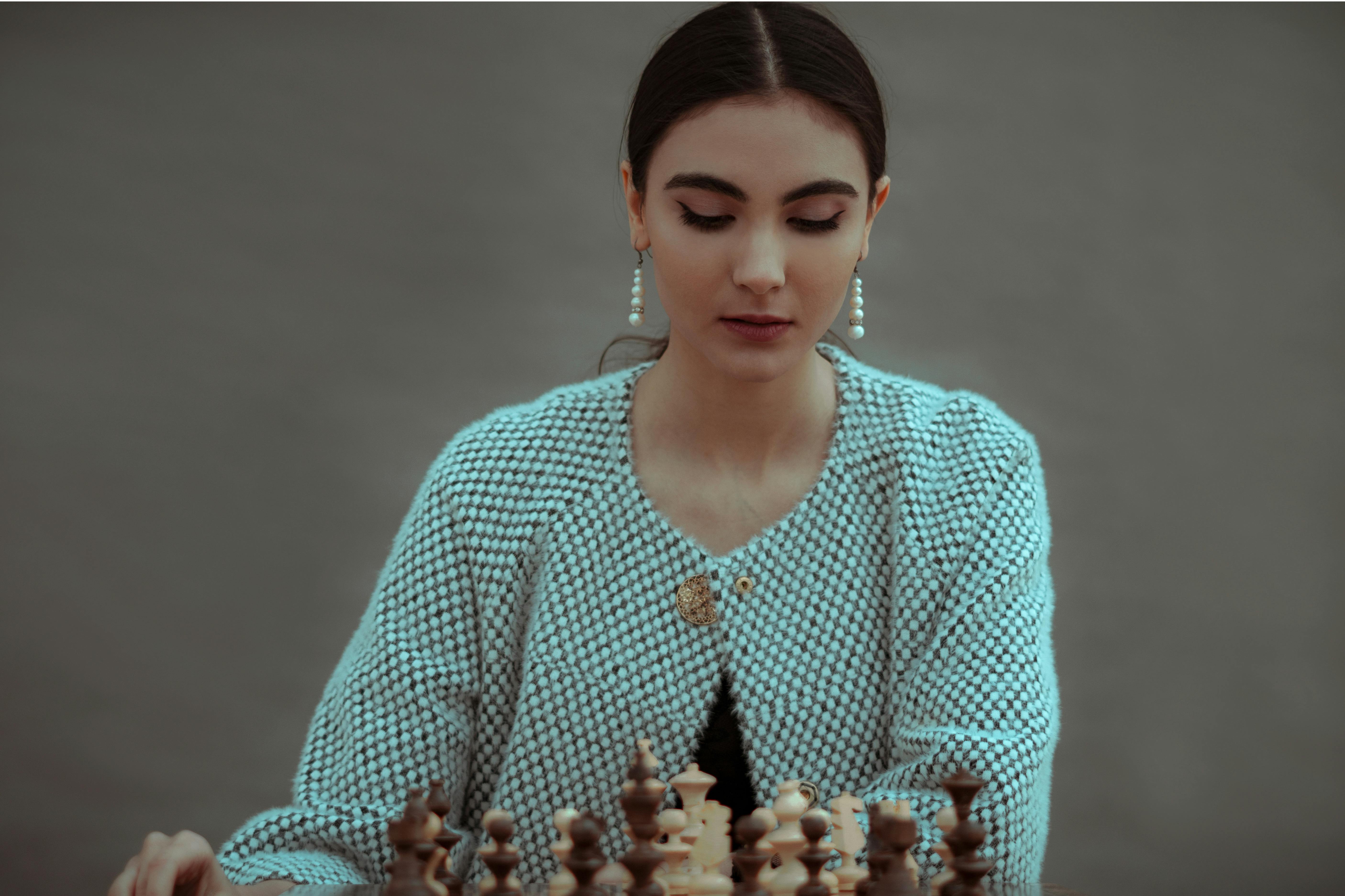 Woman playing chess thinking of next move Stock Photo - Alamy