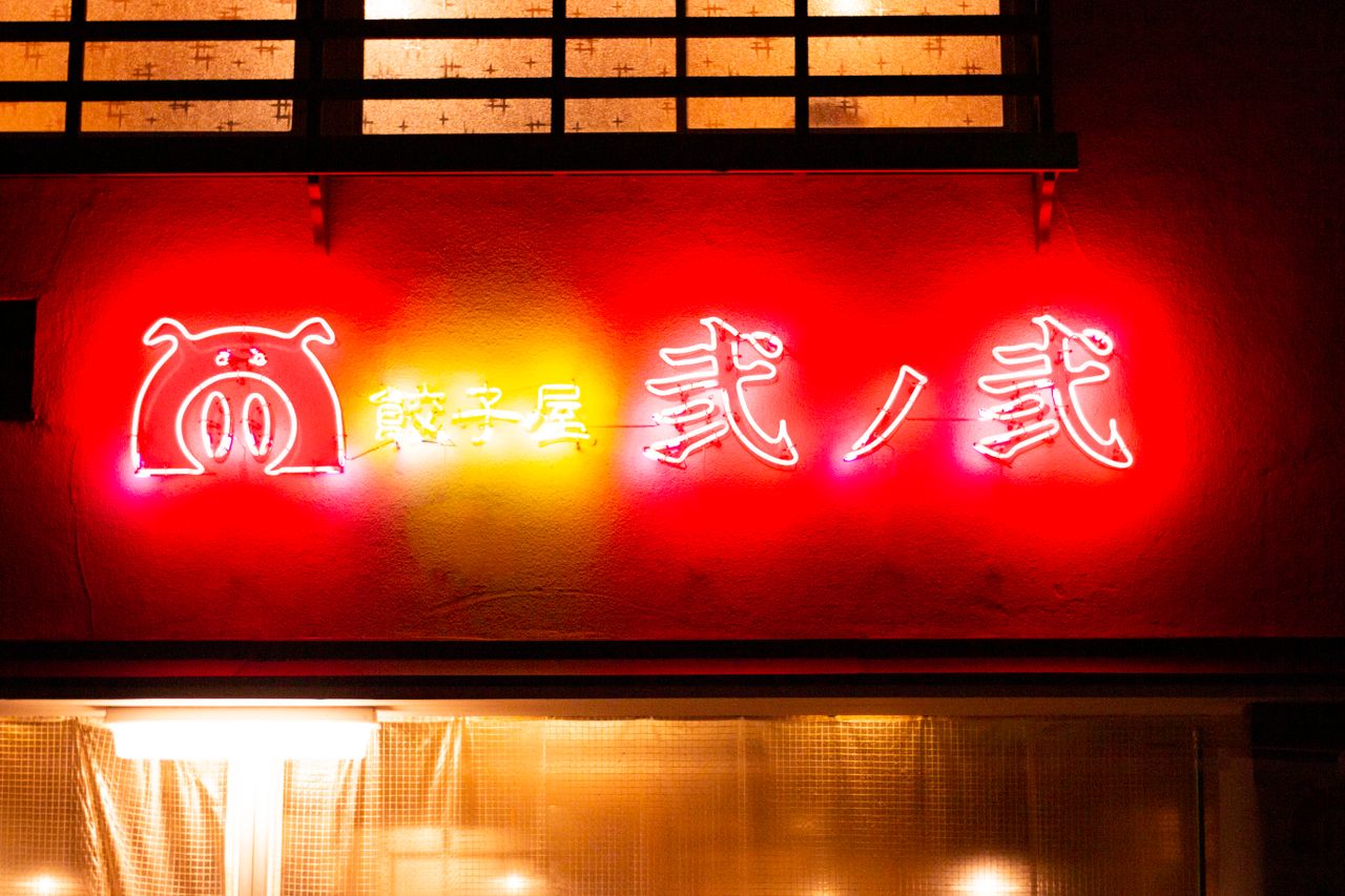 bright neon sign with hanzi characters glowing in vivid colors during