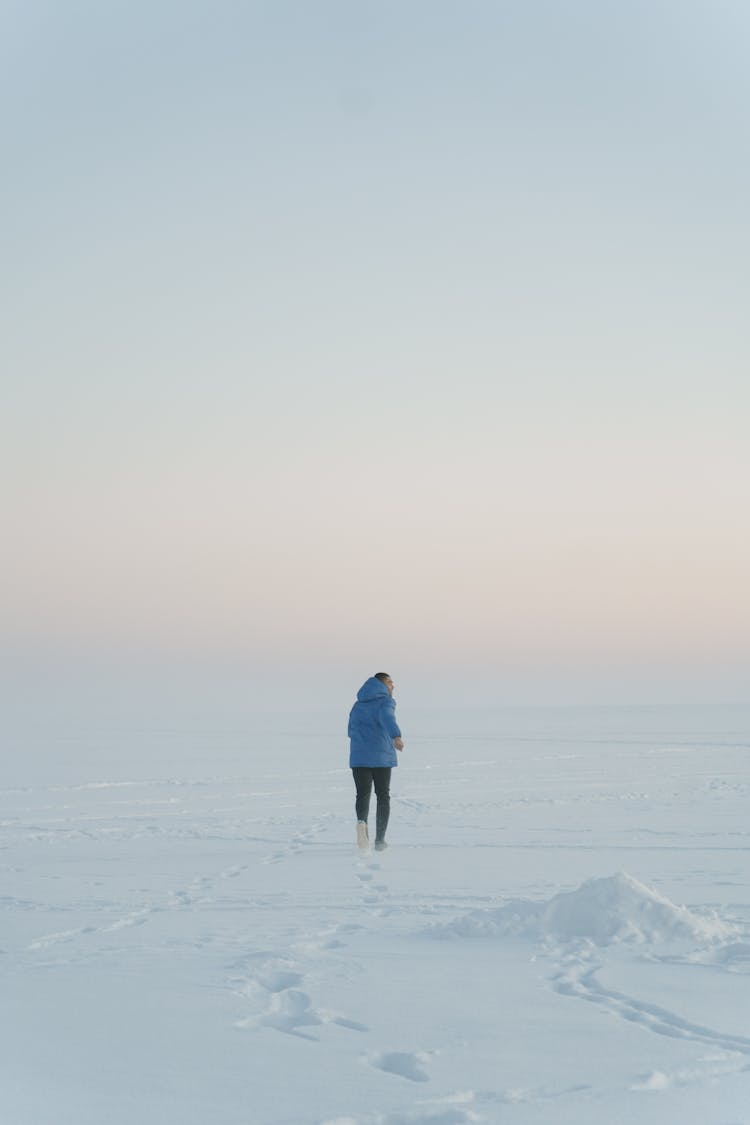 Back View Shot Of A Person Running On A Snow Covered Ground