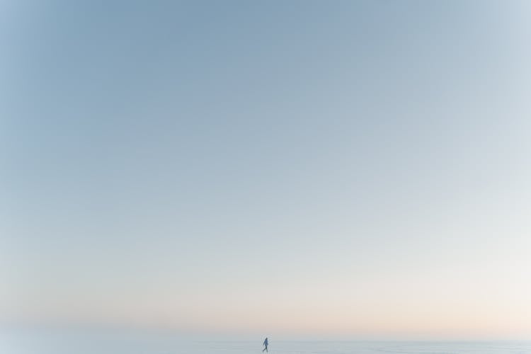 A Person Walking On Snow Covered Field