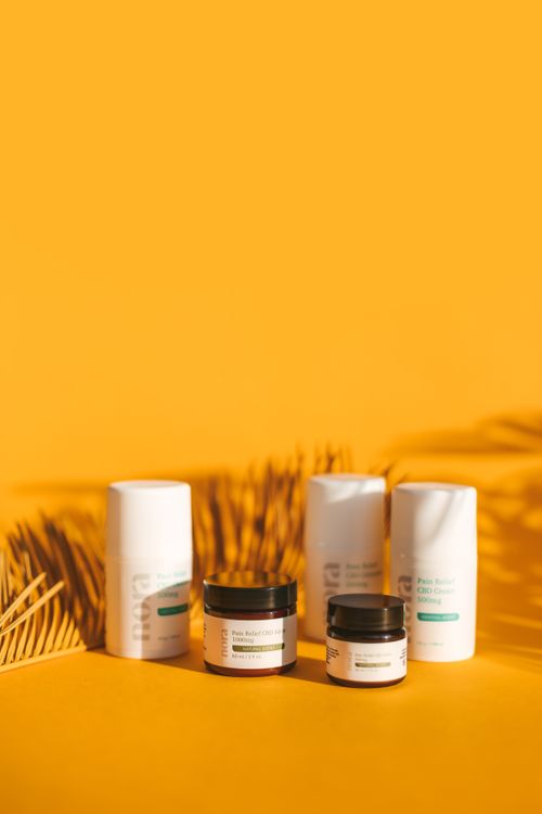 Free Clean and minimalist skincare products displayed creatively on a vibrant yellow background with natural shadows. Stock Photo