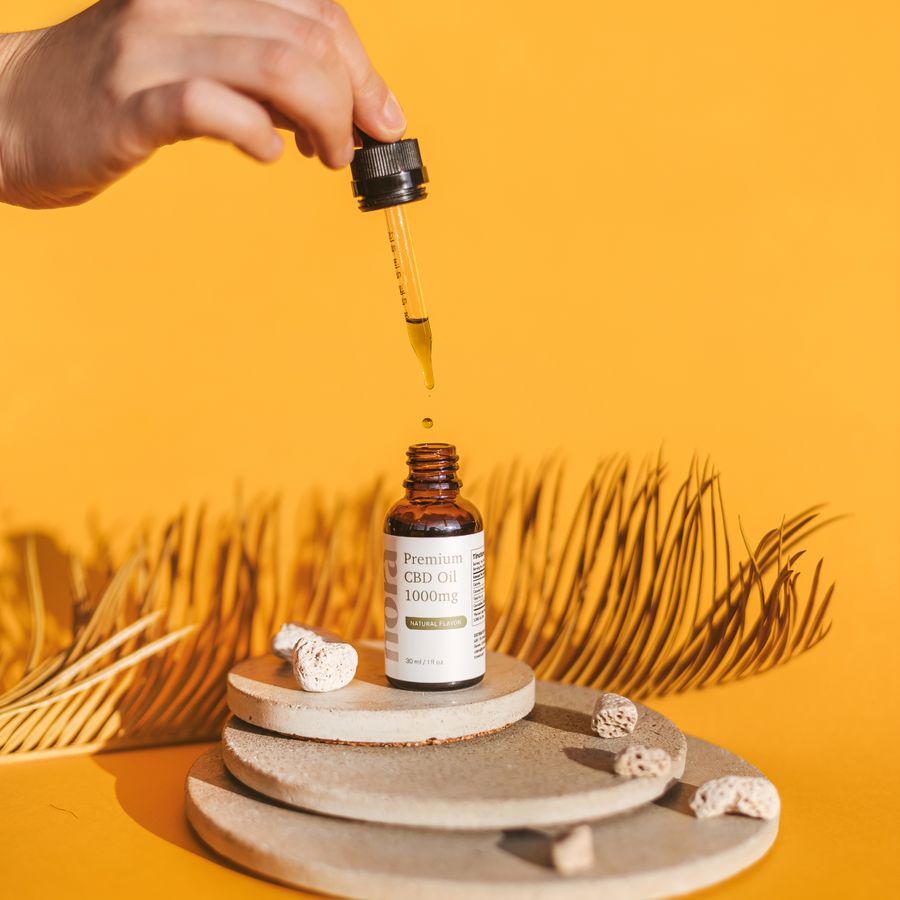 Dropper bottle of oil on an orange background