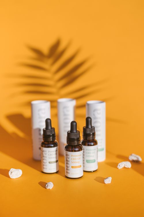 Free Collection of CBD oil dropper bottles arranged against a vibrant yellow background with shadows. Stock Photo